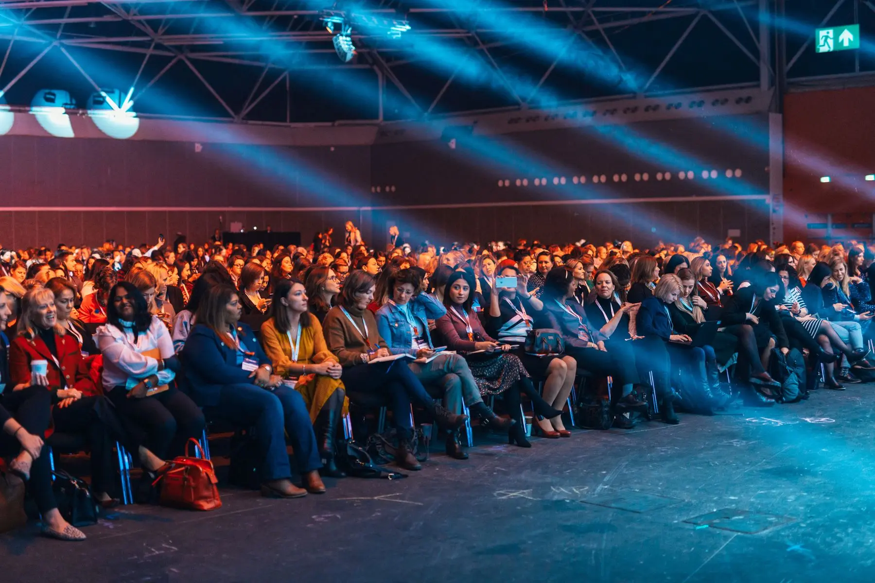 Audience gathered beneath colorful stage lights